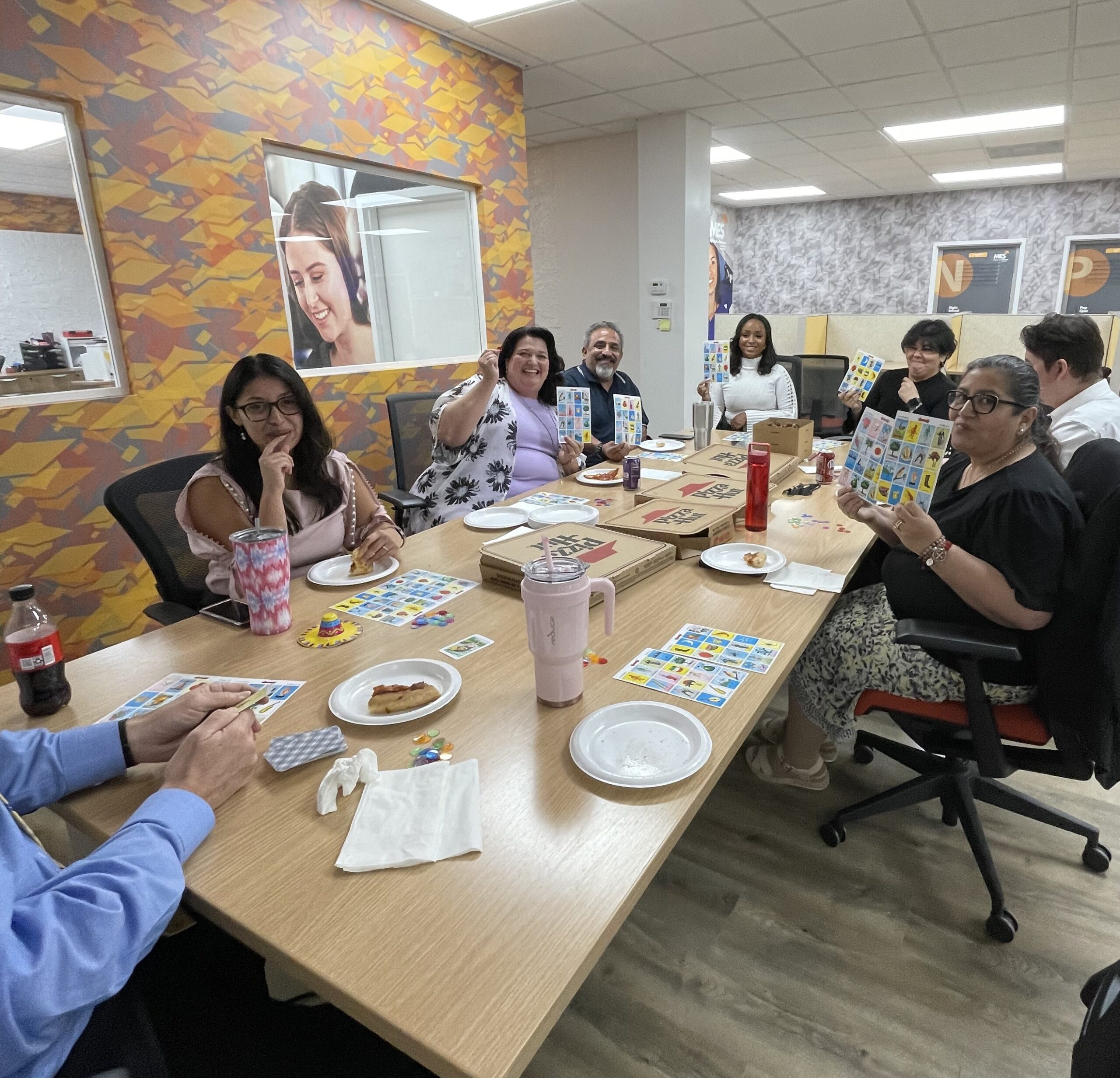 My Education Solutions employees enjoy a break with lunch from Pizza Hut and a game of Loteria